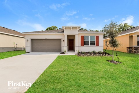 a home with a lawn and a driveway and a garage door