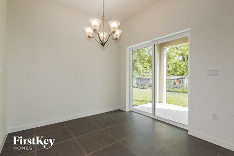 a dining room with a large window and a chandelier