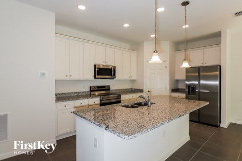 a large kitchen with granite counter tops and white cabinets