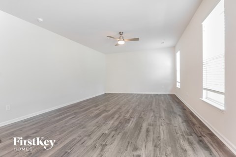 A room with wooden flooring and a ceiling fan.