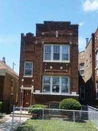a brick house with a fence in front of it