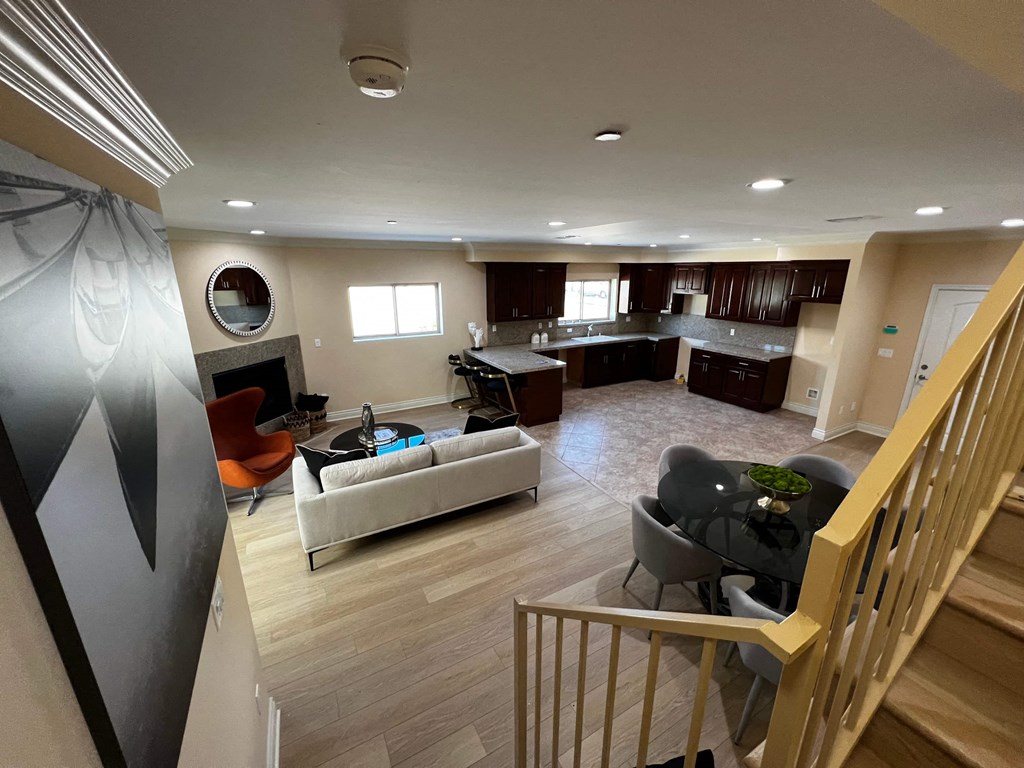 a view of a living room and a kitchen from the stairs