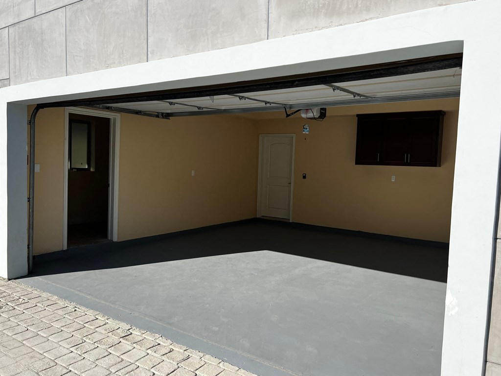 the inside of a garage with a concrete floor and a door
