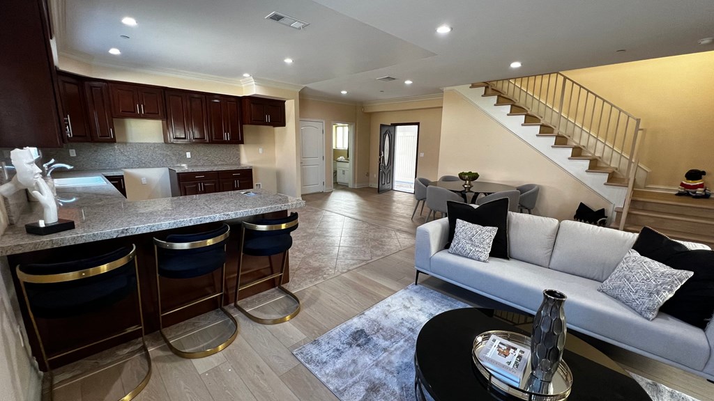 a living room with a kitchen and a staircase