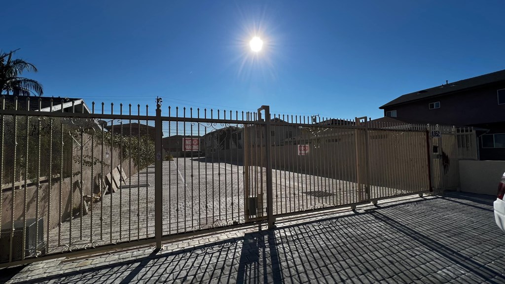 a gate to a building with the sun in the sky