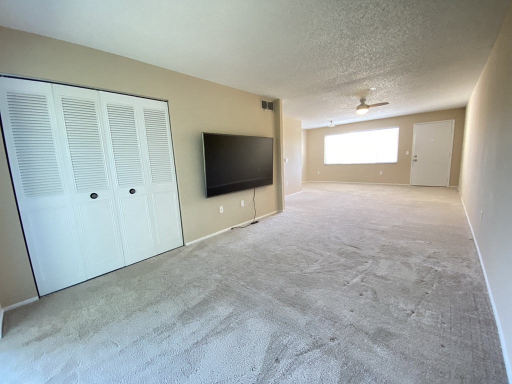 the living room of an empty apartment with a tv