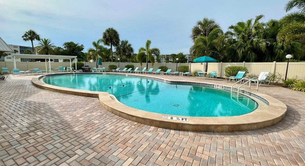 a resort style swimming pool with chairs around it