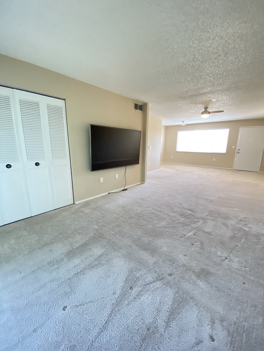 an empty living room with a tv and a closet