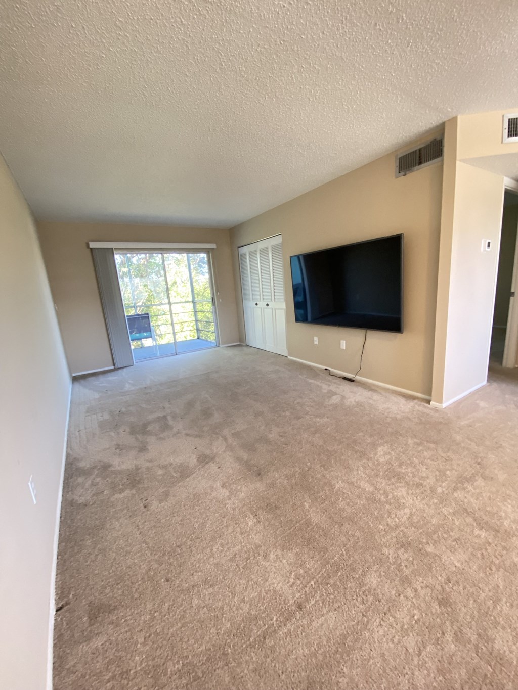 the living room of an empty apartment with a tv