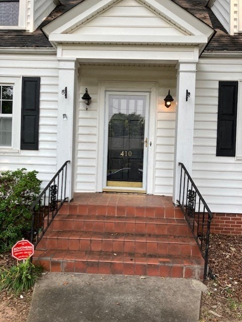 the front door of a white house with steps and a porch