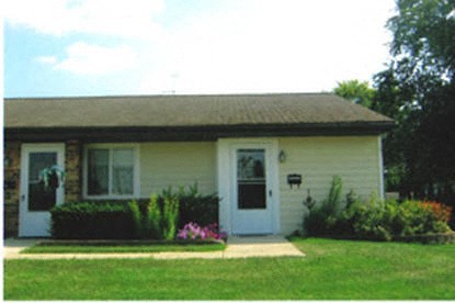 a small yellow house with a white door