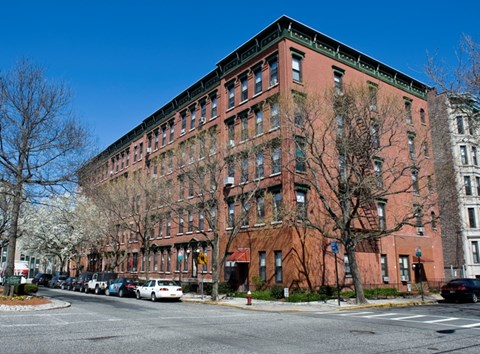 A large red brick building with a green trim around the windows and roof.