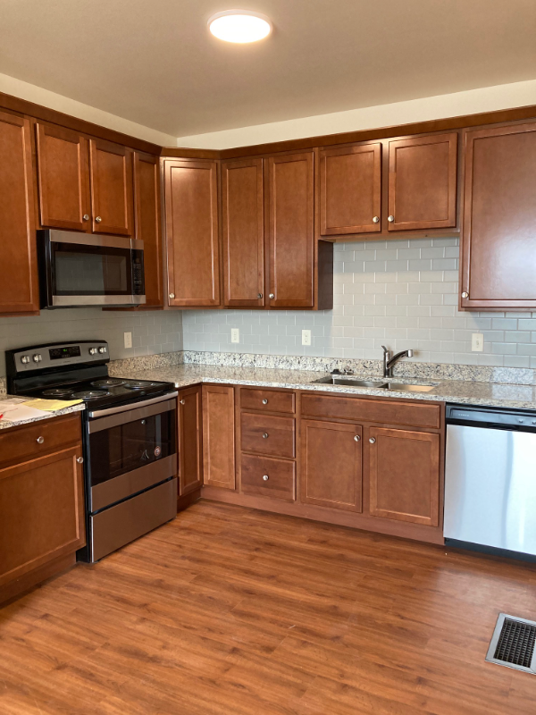 a kitchen with wooden cabinets and stainless steel appliances