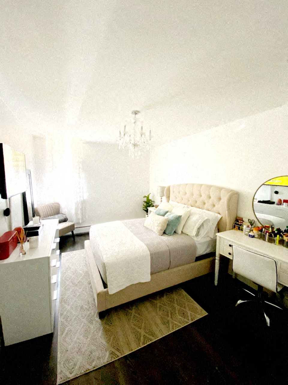 A bedroom with a large bed and a vanity table.