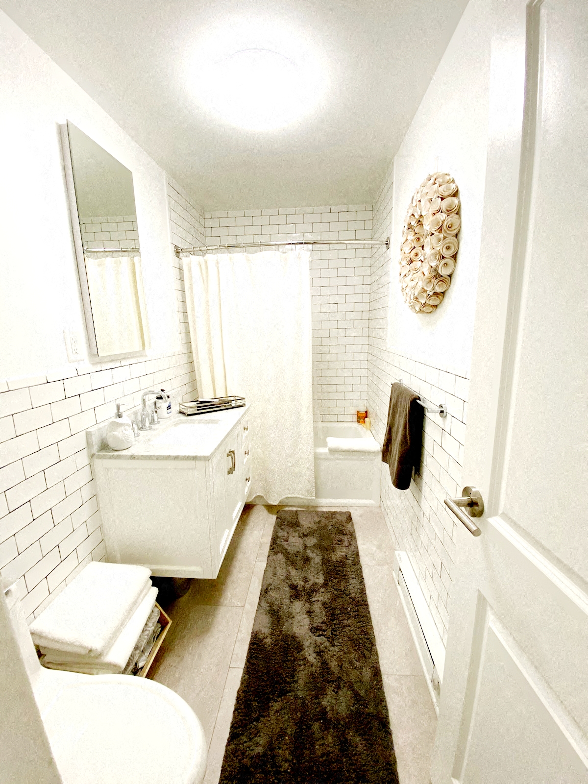 A white bathroom with a toilet, sink, and mirror.