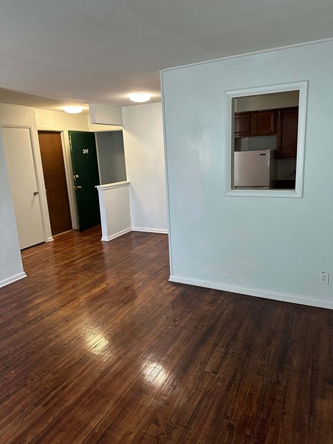 A room with wooden floors and a mirror on the wall.