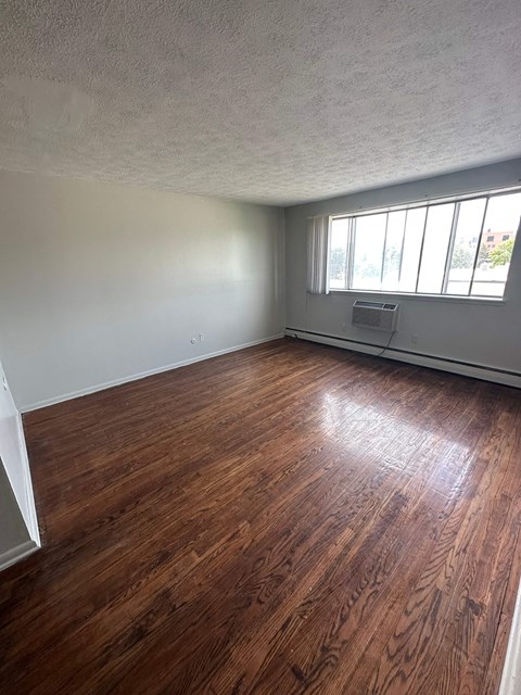 A room with wooden flooring and a window.