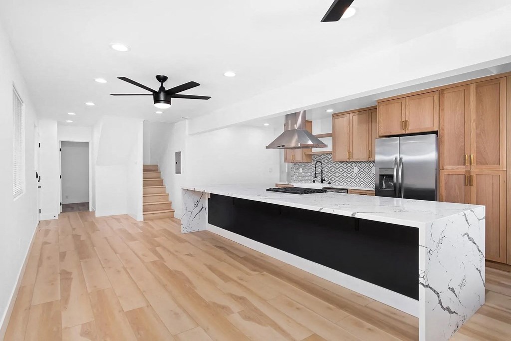 a kitchen with a marble counter top and wooden floors