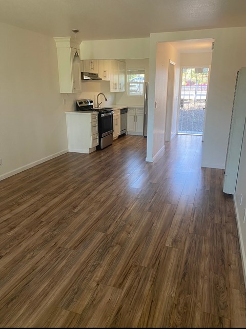 A kitchen with wooden floors and white walls.