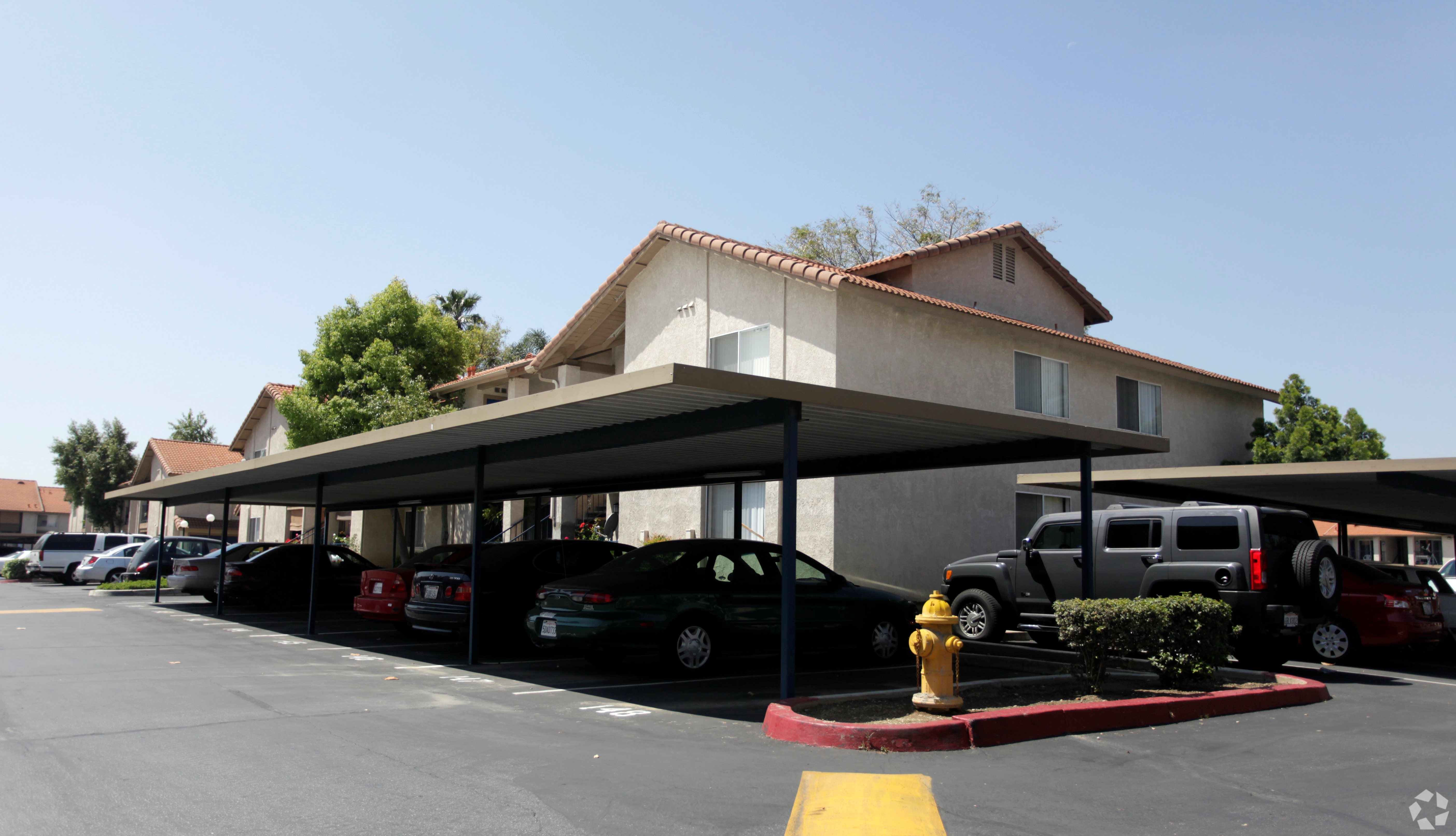 A parking lot with cars and a building in the background.