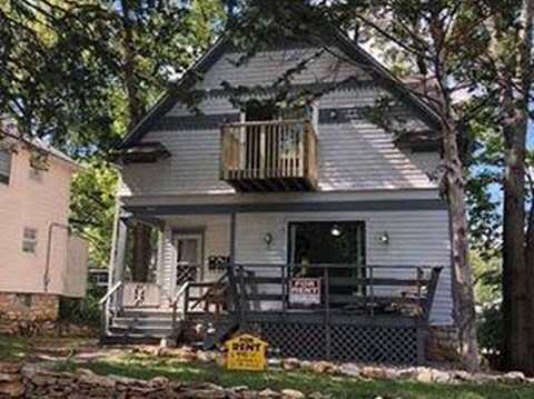 A house with a sign that says "For Sale".