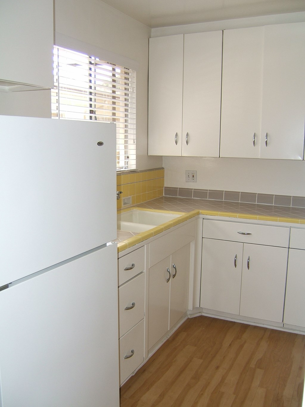 a kitchen with white cabinets and a white refrigerator