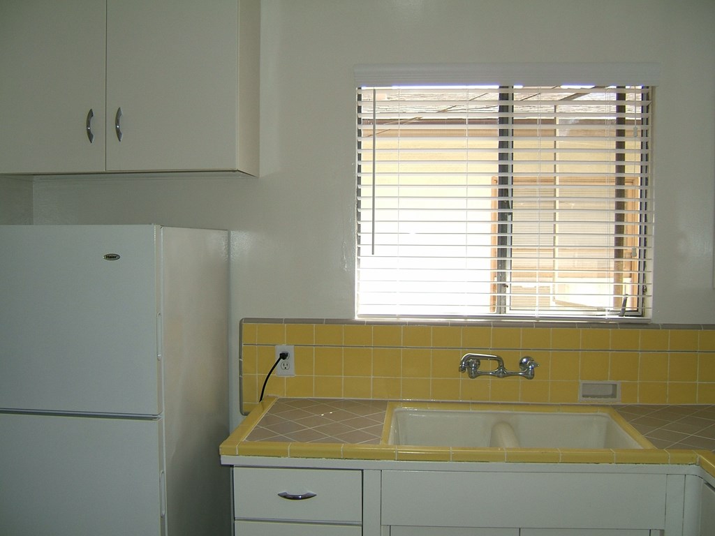 an empty kitchen with a sink and a window