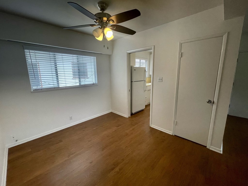 a bedroom with a ceiling fan and a door to a closet