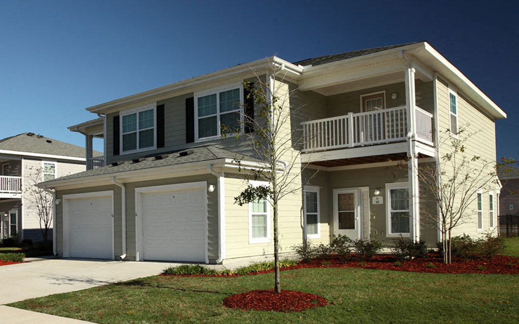 a yellow house with a porch and a balcony