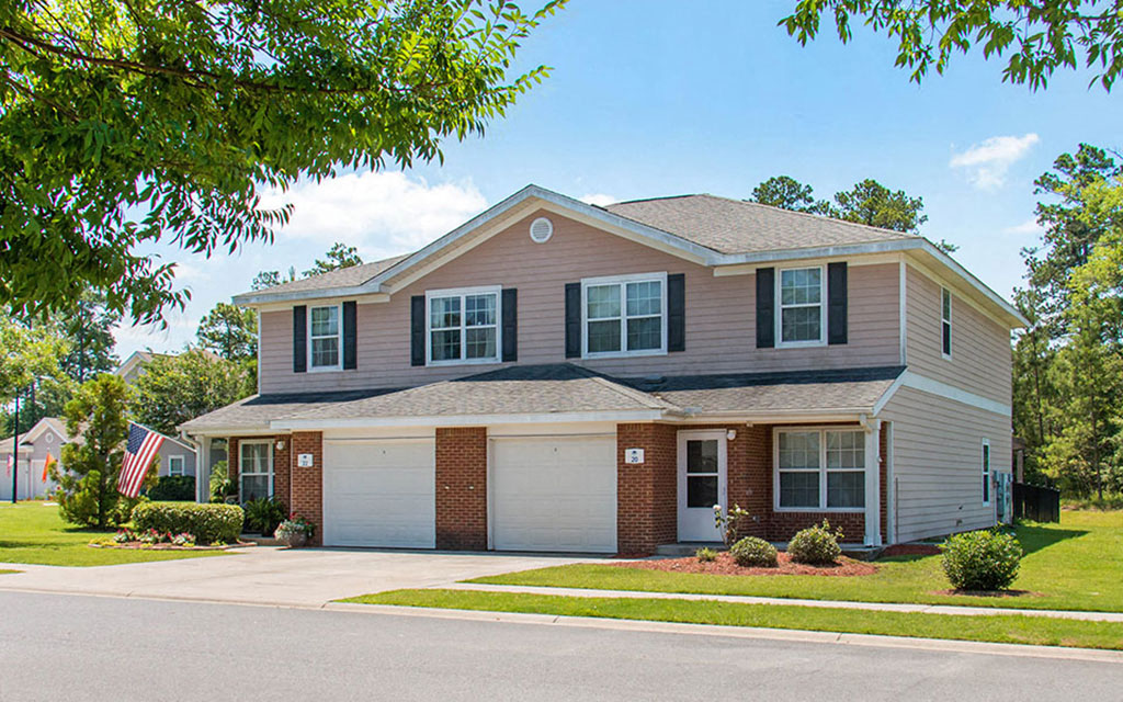 a house with a garage and a flag in front of it