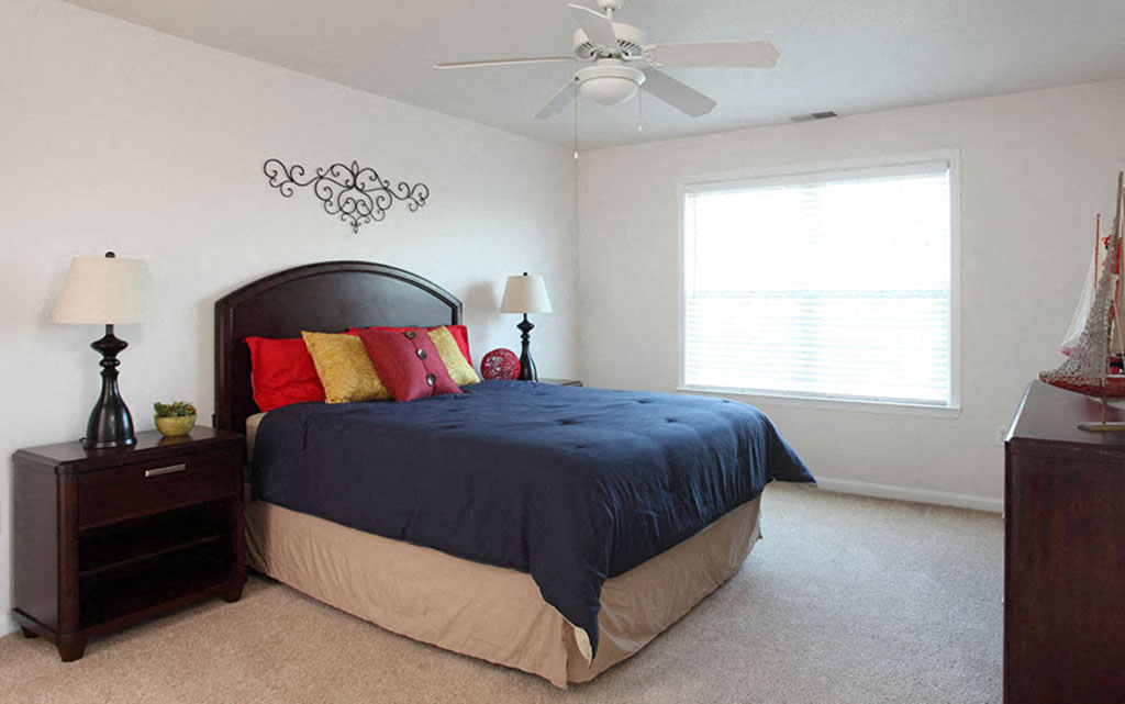 a bedroom with a bed and a ceiling fan
