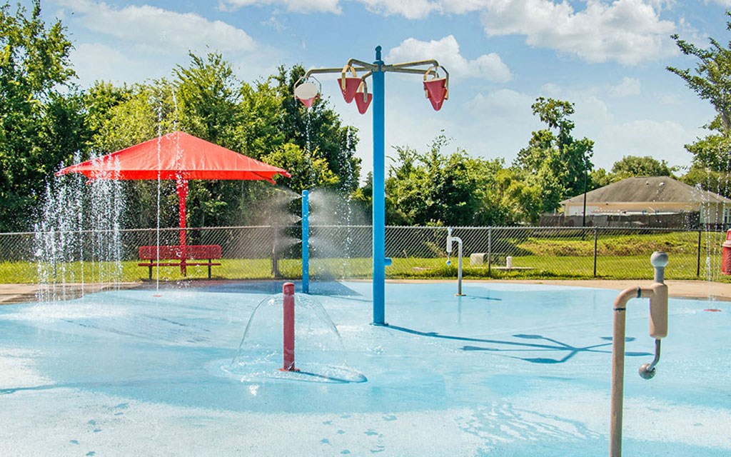 a splash park with a water fountain and a umbrella