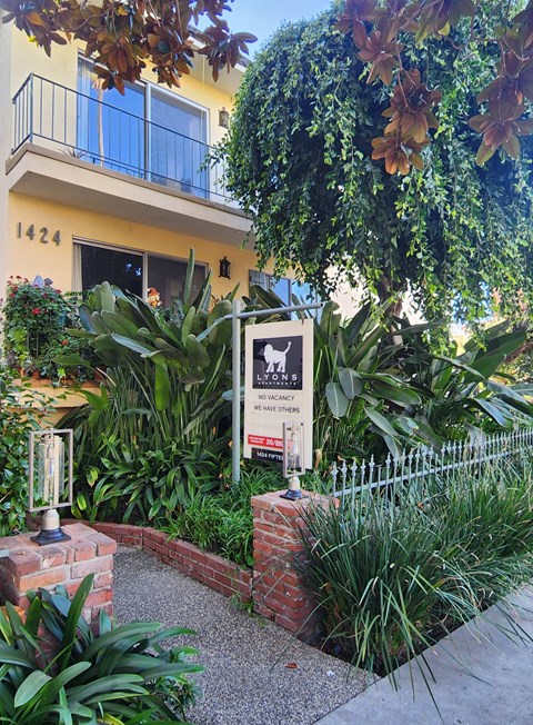 A sign in front of a house that says "No Pets Allowed".