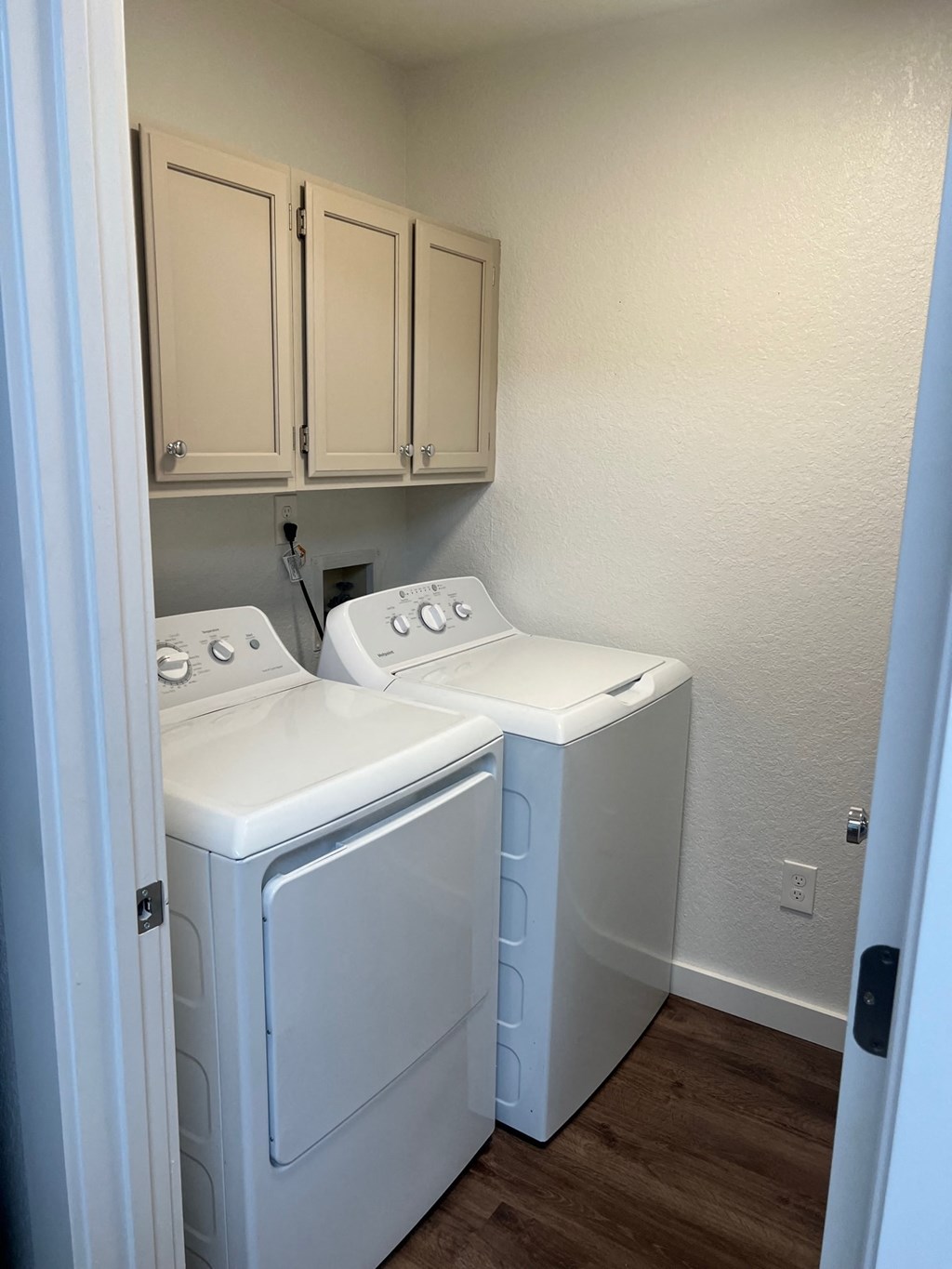 a washer and dryer in a room with white cabinets