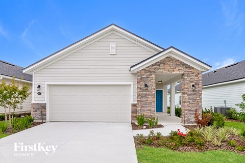 a white house with a garage door and a driveway
