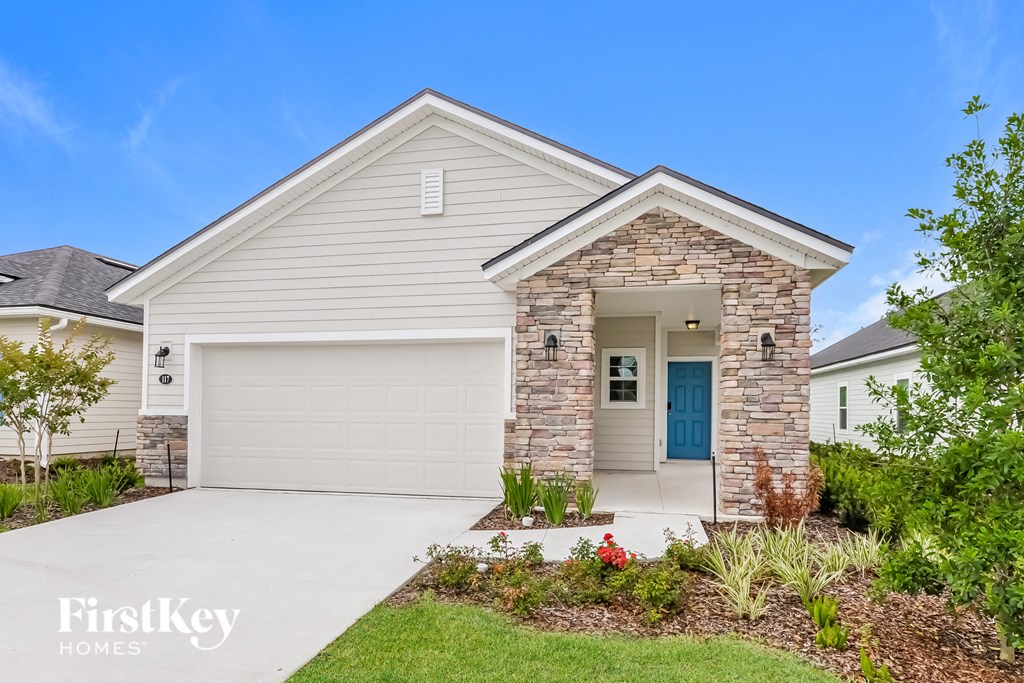 a white house with a blue door and a driveway
