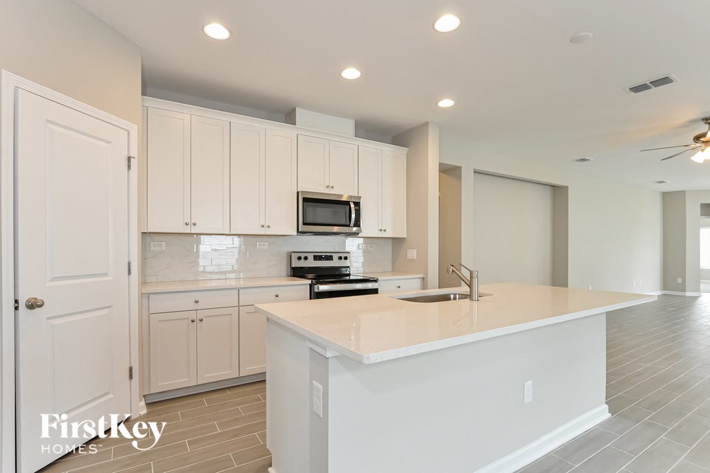 a large kitchen with white cabinets and a white counter top