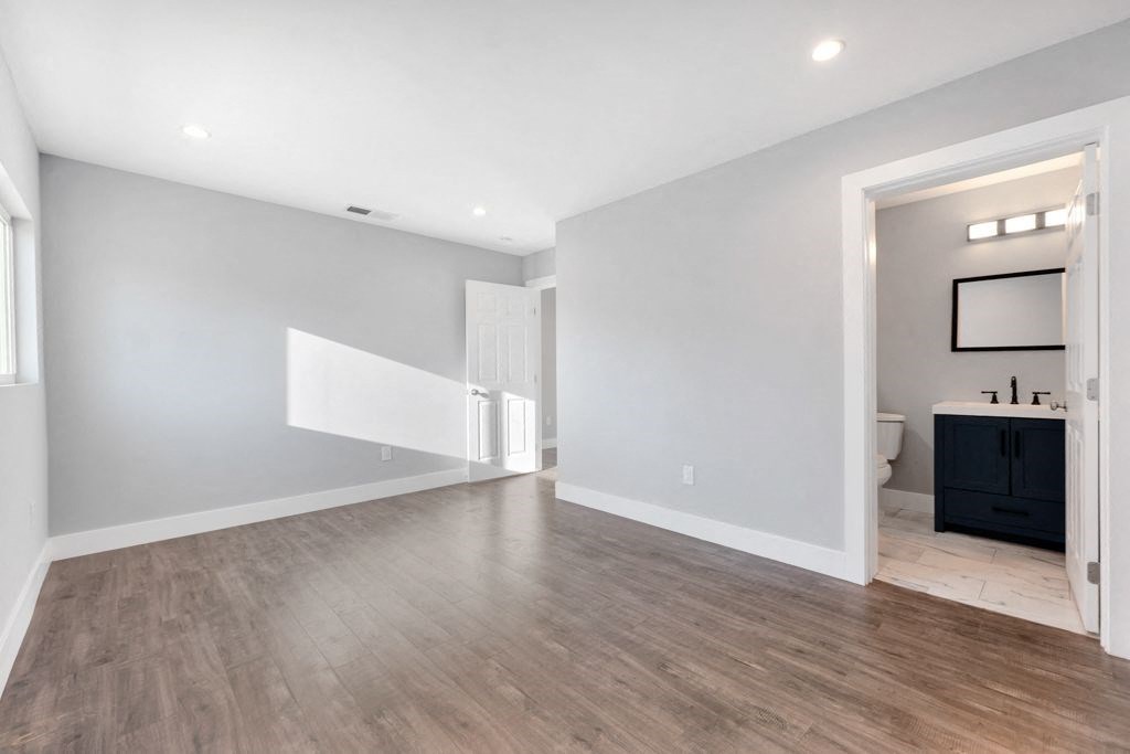 the living room and dining room of a new home with white walls and wood floors