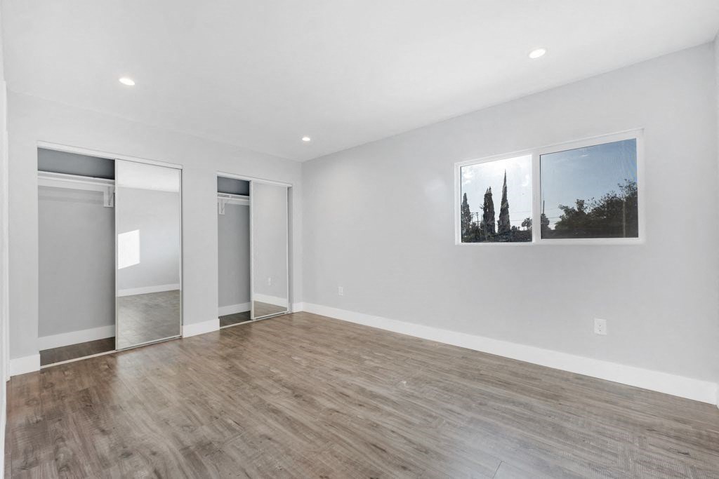 the living room of a new home with white walls and wood flooring
