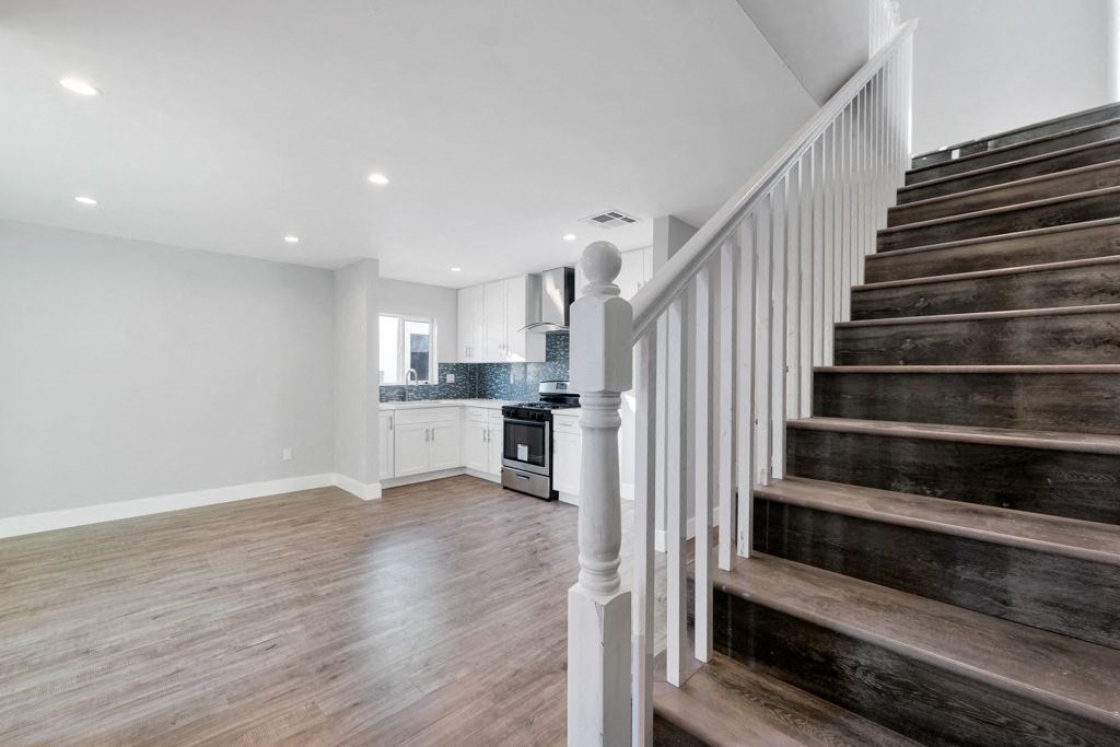 a staircase in a house with a kitchen in the background