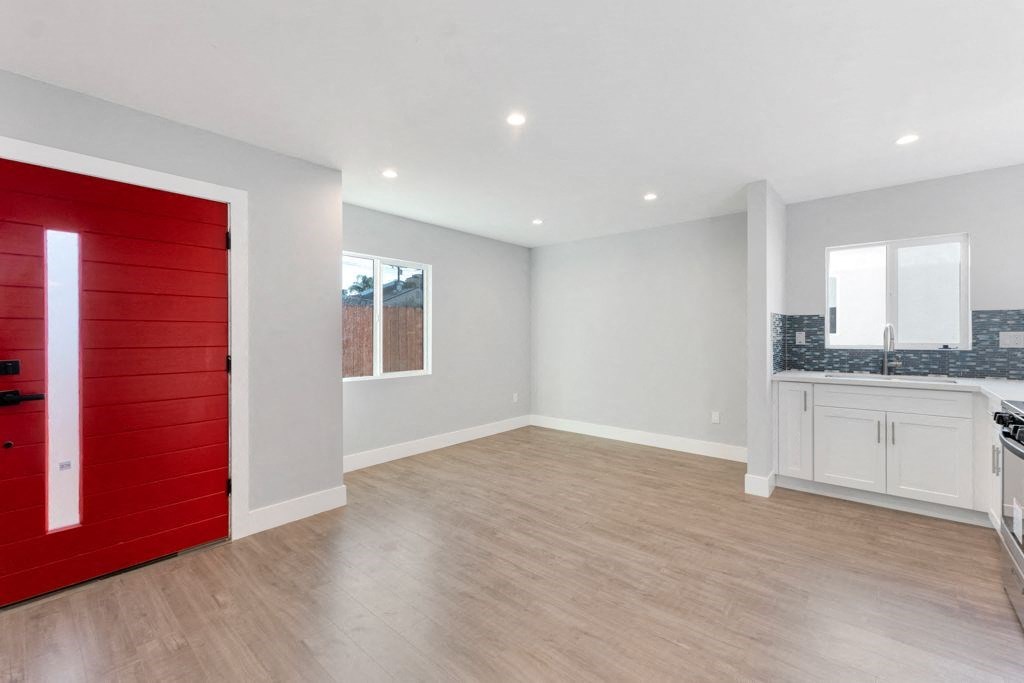 an empty room with a red door in the middle of it