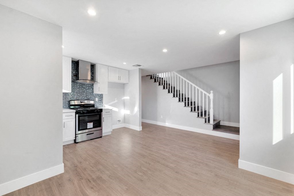 a living room with a kitchen and a staircase
