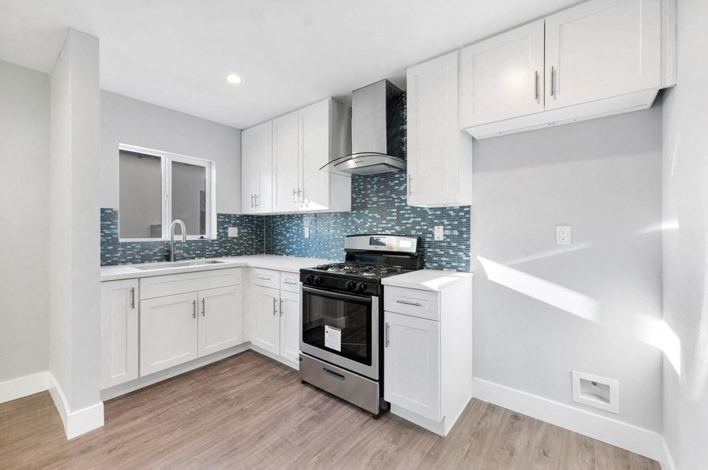 a kitchen with white cabinets and a stove top oven