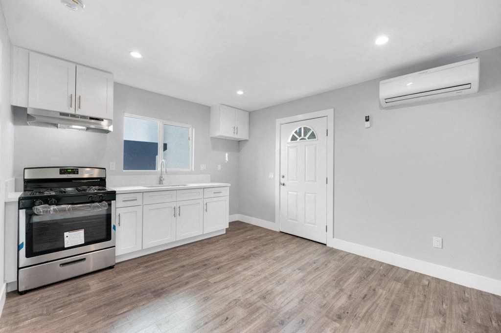 a white kitchen with a stove and a refrigerator