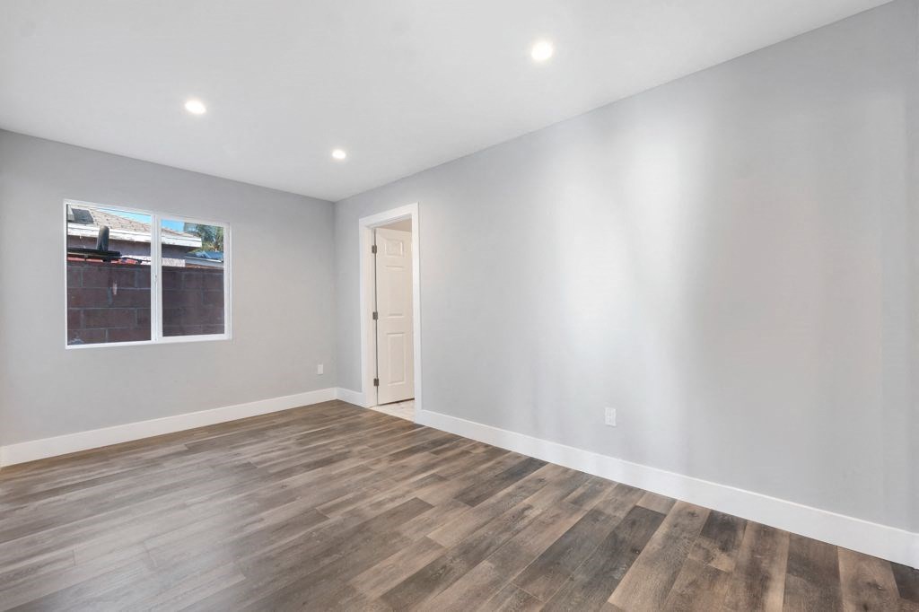 a living room with white walls and wood floors