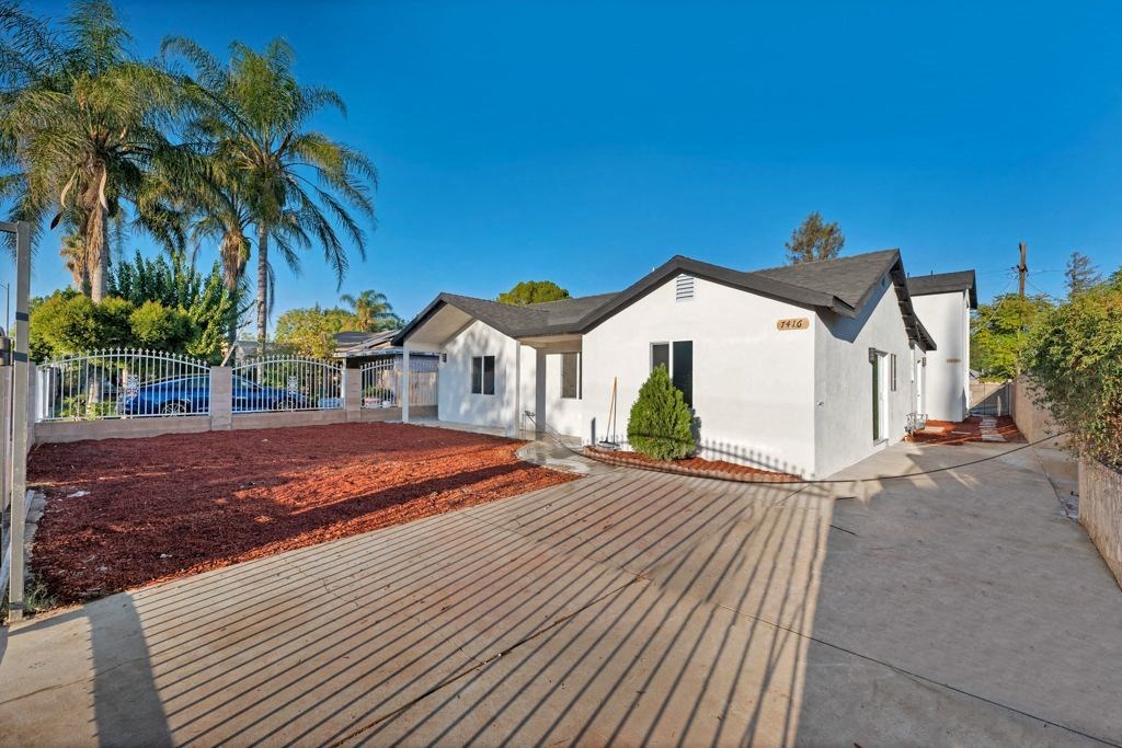 a small white house with a yard and a deck