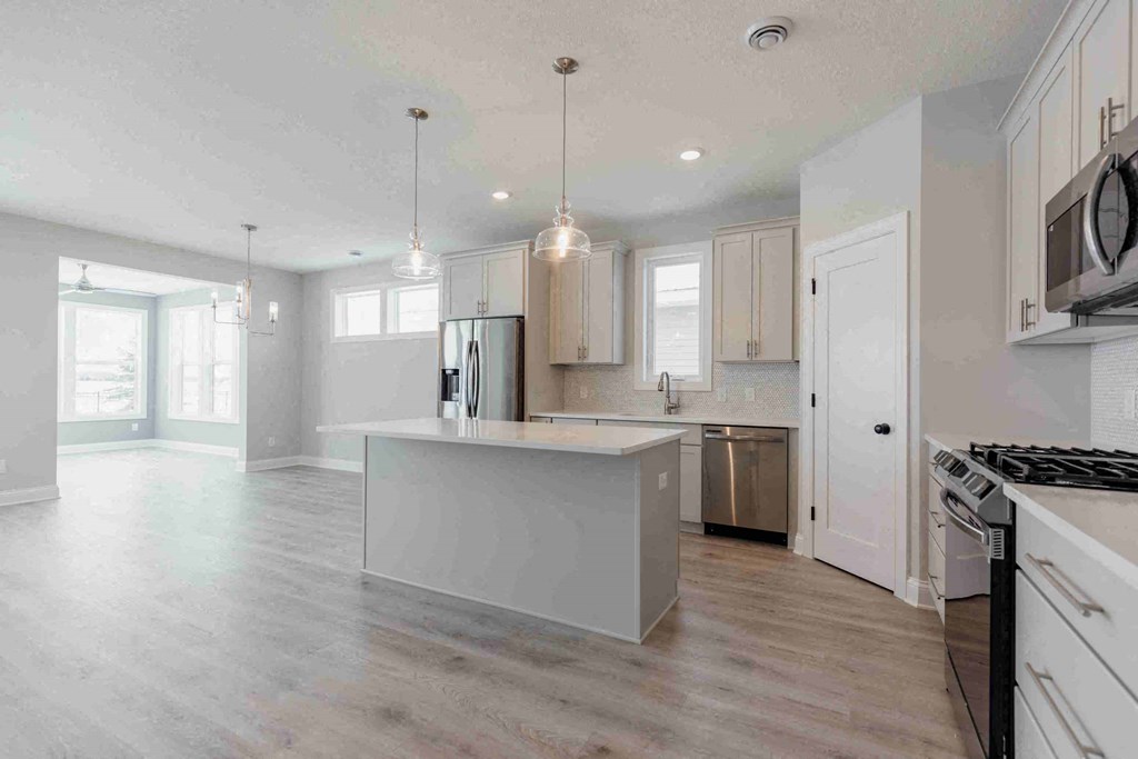 a white kitchen with a large island in the middle