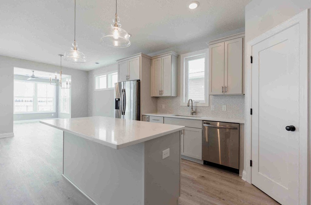 a white kitchen with a large island in the middle