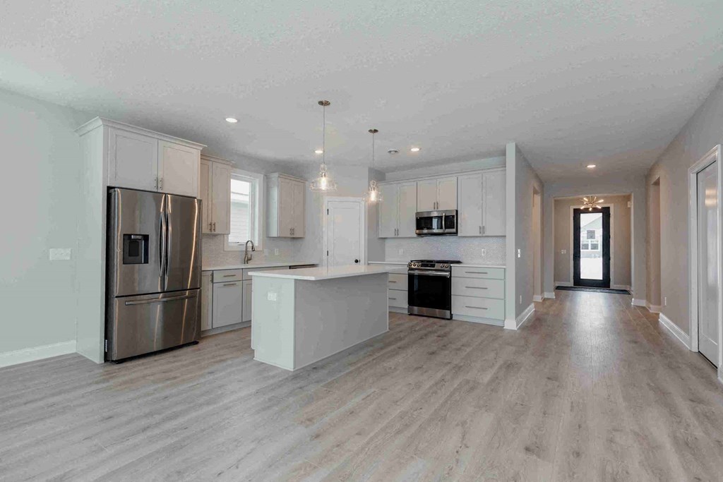 an open kitchen with white cabinets and stainless steel appliances