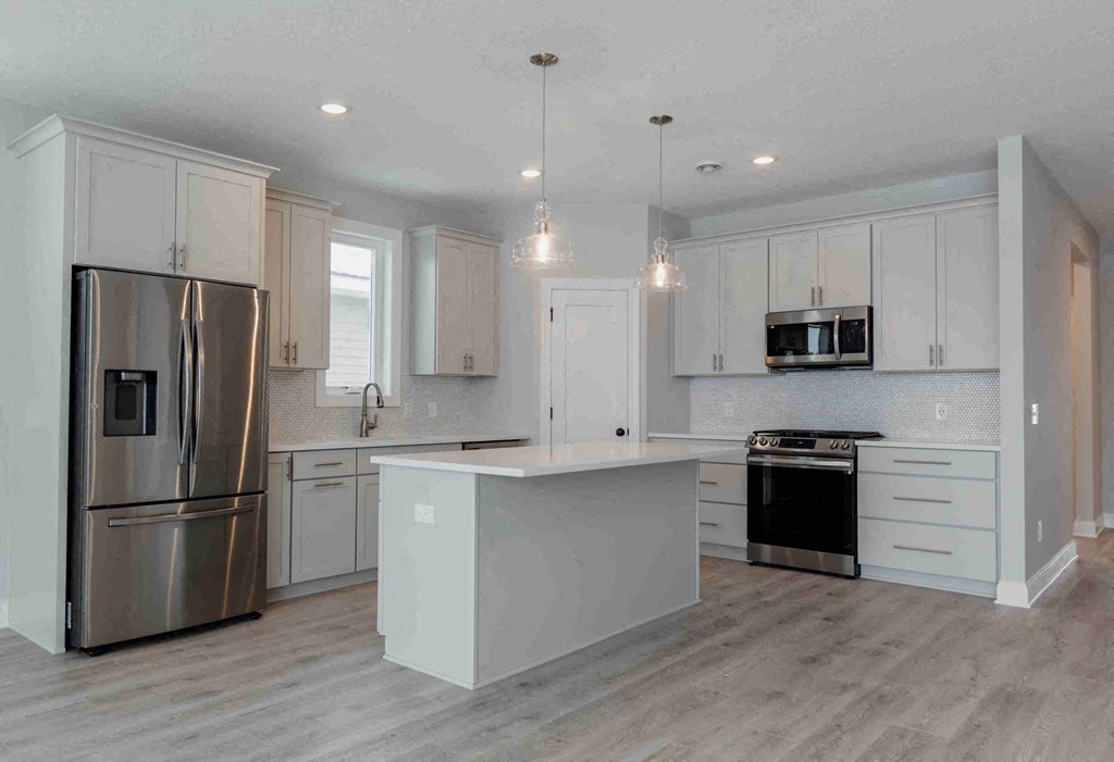 a white kitchen with stainless steel appliances and white cabinets